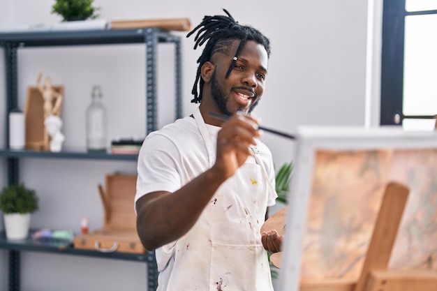 Mulher afro-americana sorrindo confiante desenhando no estúdio de arte