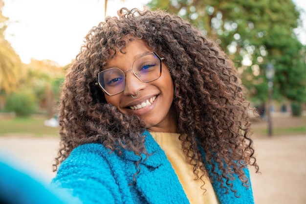 Foto mulher afro-americana sorrindo tirando selfie de uma garota na moda alegre e positiva posando