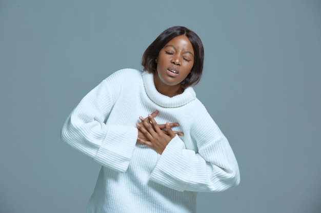 Mulher afro-americana sufocando sentindo dor tocando o peito sofre de dor de cabeça falta de
