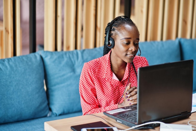 Mulher afro-americana trabalha em um operador de call center e agente de atendimento ao cliente usando fones de ouvido de microfone trabalhando no laptop