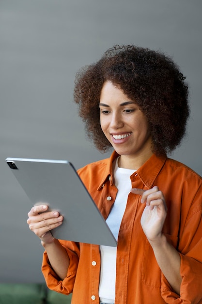 Mulher afro-americana usando tablet digital fazendo compras on-line pedindo comida em casa