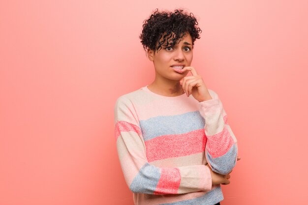 Foto mulher afro-americano misturada nova do adolescente que relaxa pensando sobre algo que olha um espaço da cópia.