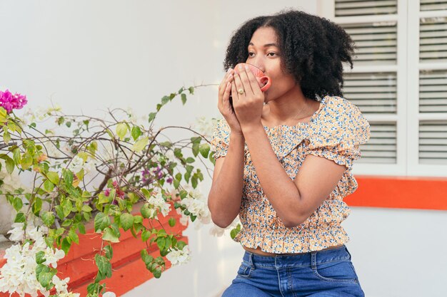 Mulher afro bebendo café ao ar livre