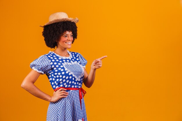 Mulher afro brasileira com roupas típicas da Festa Junina em amarelo