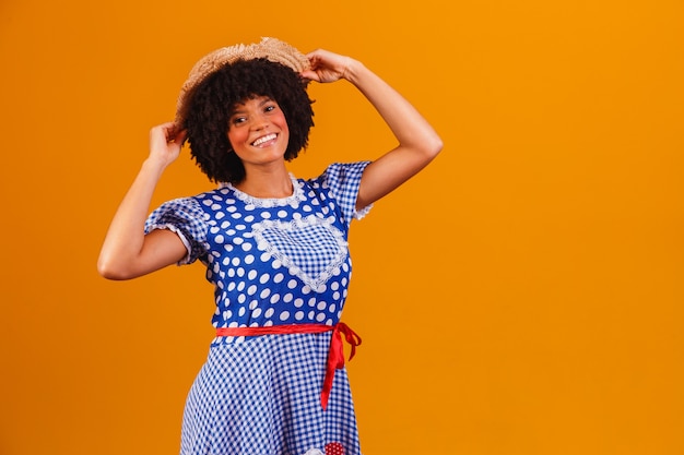 Mulher afro brasileira com roupas típicas da Festa Junina em amarelo