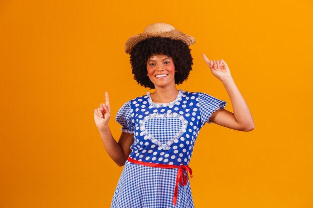 Mulher afro brasileira com roupas típicas da festa junina em amarelo