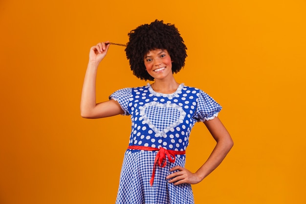 Mulher afro brasileira com roupas típicas da Festa Junina em amarelo