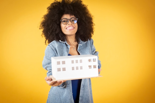 Mulher afro com arquiteto de óculos, fundo amarelo