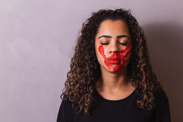 Mulher afro com marca de mão na boca em prol da conscientização do feminicídio. Violência doméstica