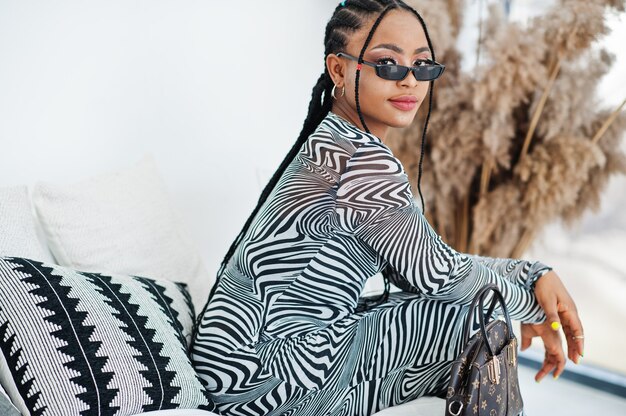 Foto mulher afro com vestido de zebra em pose interna