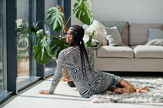 Mulher afro com vestido de zebra em pose interna