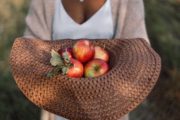 Mulher afro em pomar de macieiras