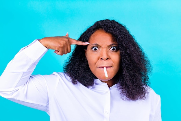 Foto mulher afro ganhando com problemas de nicotina viciada para parar de fumar estúdio azul fundo