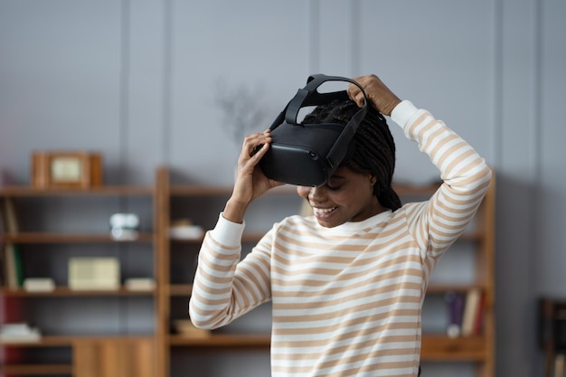 Mulher afro inspirada em casa colocou capacete vr para desfrutar de simulação cibernética de jogo online de realidade virtual