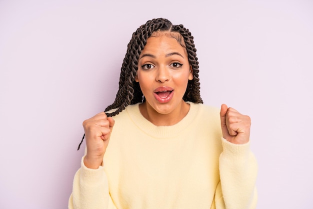 Mulher afro negra se sentindo chocada rindo e comemorando o sucesso