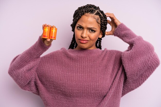 Mulher afro negra se sentindo confusa e confusa, coçando a cabeça. conceito de bateria