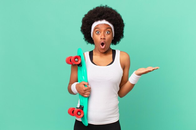 Mulher afro parecendo surpresa e chocada, com o queixo caído segurando um objeto com a mão aberta ao lado. conceito de skate