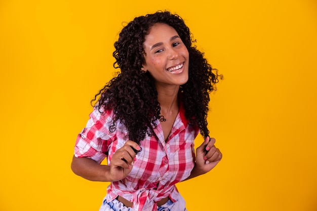 Mulher afro vestida com roupa de festa junina e cabelo preso por maria chiquinha