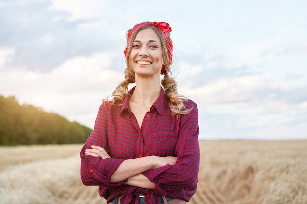 Mulher agricultora em pé em um campo de trigo