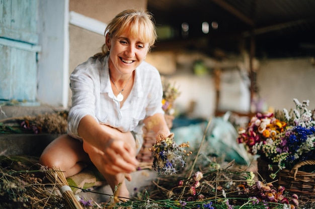 mulher agricultora faz lindos buquês com um monte de flores secas cultivadas no país