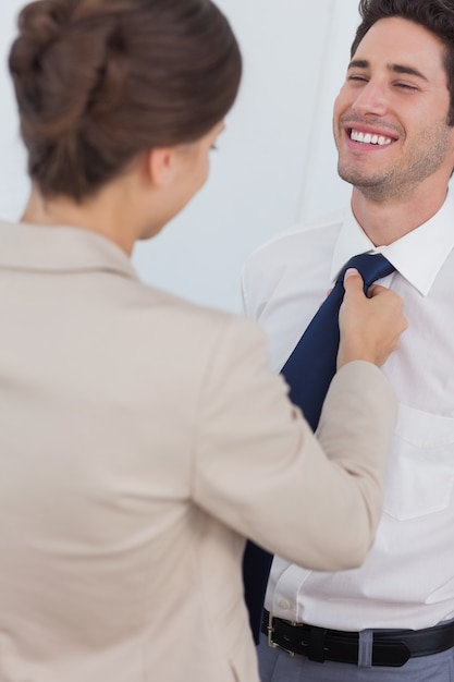 Foto mulher ajudando o marido sorridente a amarrar sua gravata