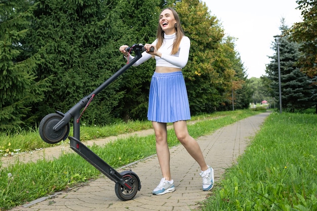 Mulher alegre colocando sua scooter elétrica em uma roda