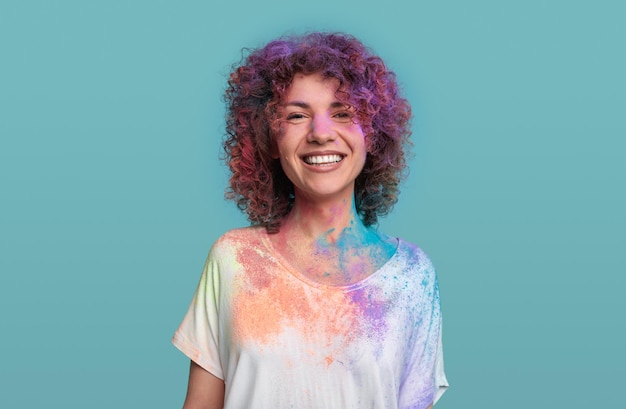 Foto mulher alegre com pó de holi no rosto e roupas