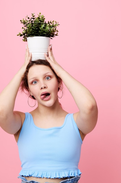 Foto mulher alegre em vaso de flores posando planta vista cortada inalterada