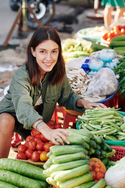 Mulher alegre escolhendo vegetais