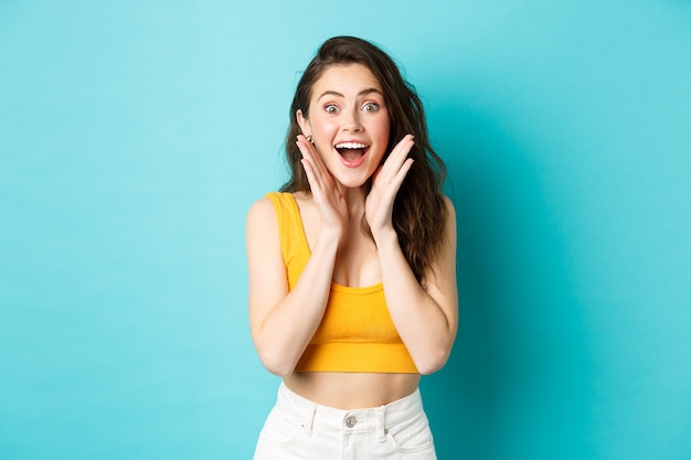 Mulher alegre jovem de conceito de verão e estilo de vida olhar com cara de surpresa para a câmera reagir ao espanto ...