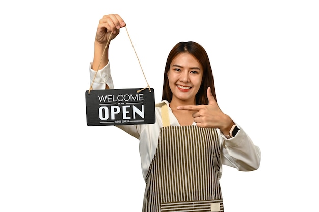 Mulher alegre proprietária de uma pequena empresa em avental segurando um sinal de OPEN e sorrindo para a câmera isolada em fundo branco