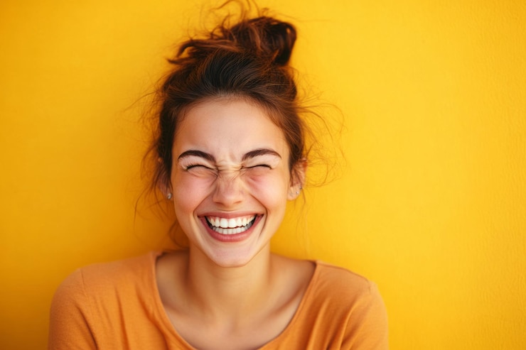 Foto mulher alegre rindo contra um fundo amarelo