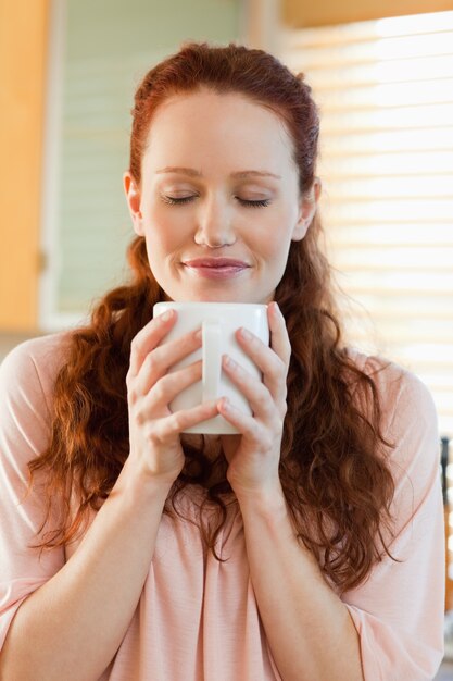 Mulher alegre segurando uma xícara de café