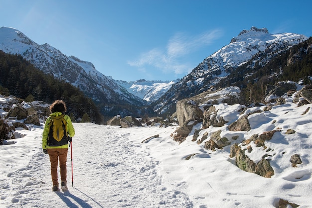 Mulher alpinista andando nas montanhas nevadas dos Pirinéus