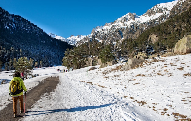 Mulher alpinista andando nas montanhas nevadas dos Pirinéus