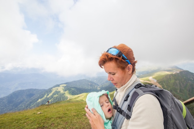 Mulher alpinista com criança dormindo