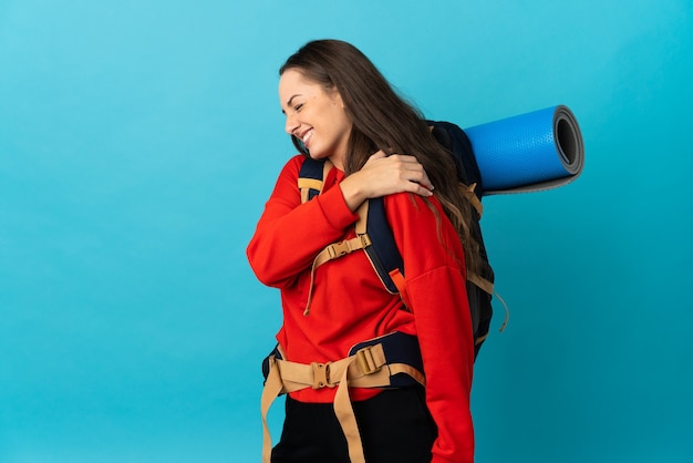 Mulher alpinista com uma grande mochila na parede isolada com dor no ombro por ter feito um esforço