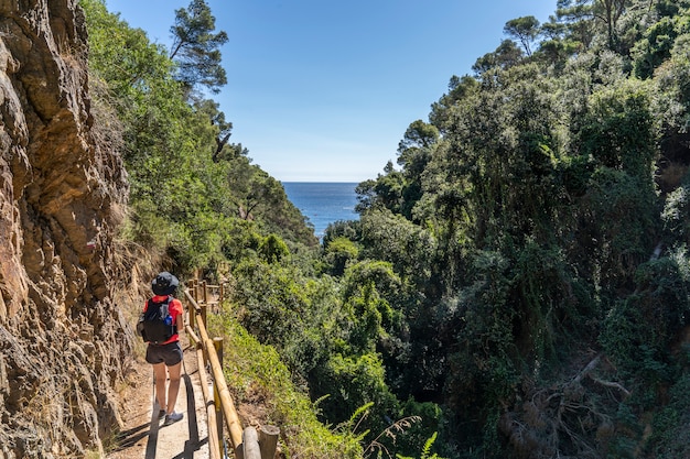 Mulher alpinista descendo em direção à praia.