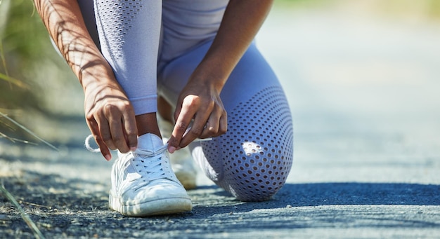 Foto mulher amarrando cadarços tênis e mãos começam a correr para fitness e saúde cardiovascular e pessoa ativa ao ar livre corredora saudável e ativa pronta para treinamento e sapatos de corrida com espaço de maquete