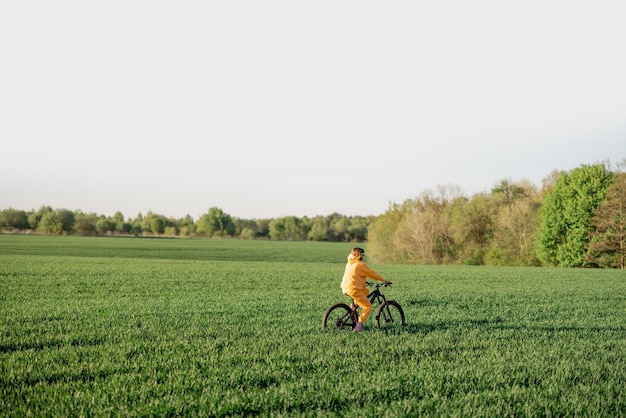 Mulher anda de bicicleta em um campo