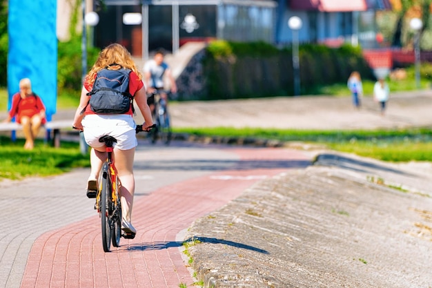 Mulher andando de bicicleta. Nida resort perto de Klaipeda em Neringa no Curonian Spit no Mar Báltico, na Lituânia.