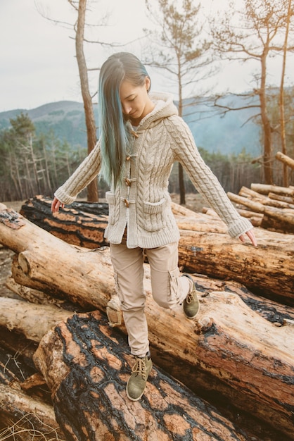 Foto mulher andando em troncos de árvores