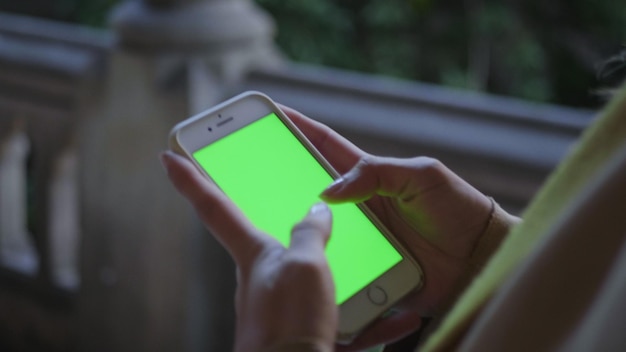 Mulher andando no corredor Empresária digitando no celular com tela verde