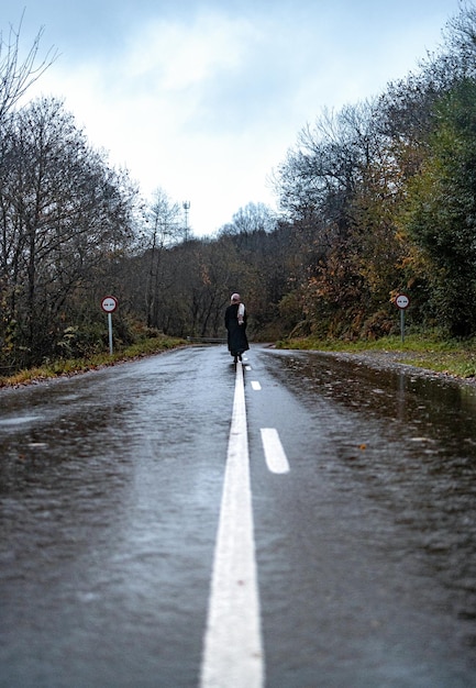 Mulher andando pela estrada na paisagem de outono