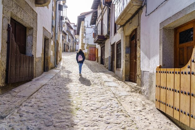 Mulher andando por um beco com antigas casas medievais Candelario Salamanca