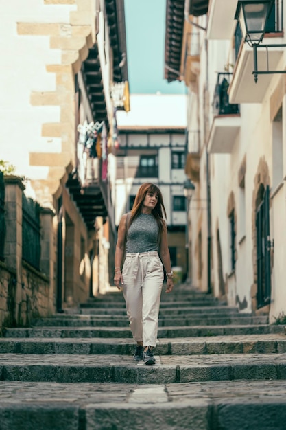 Mulher andando por uma rua de escada de pedra