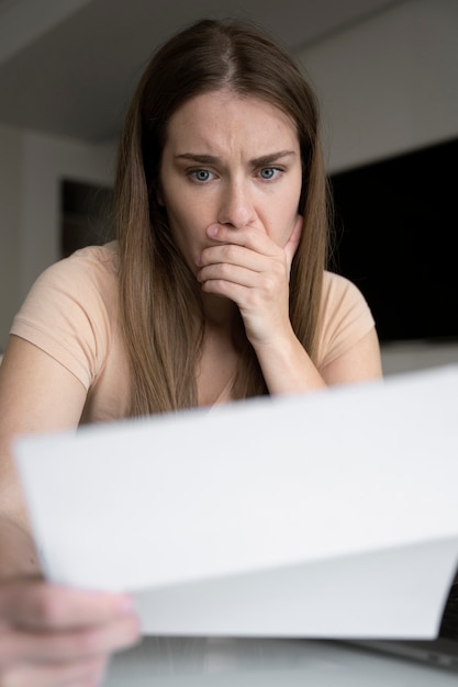 Mulher ansiosa de baixo ângulo lendo papel