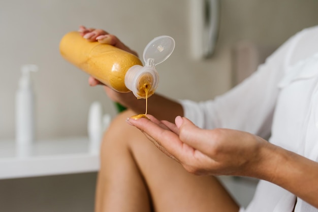 Mulher aplica um hidratante cosmético para cuidados com a pele