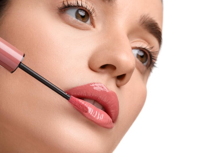 Foto mulher aplicando brilho labial em fundo branco