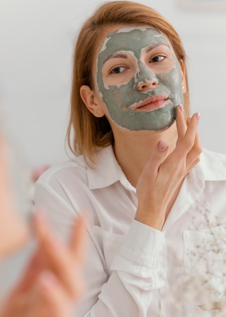 Mulher aplicando máscara facial